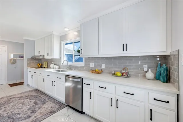 a kitchen with cabinets appliances a sink and a counter top space