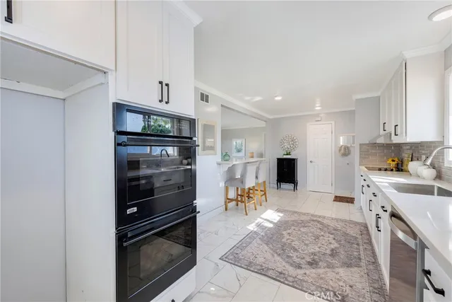 a kitchen with stainless steel appliances granite countertop a refrigerator stove top oven and sink