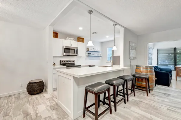 a kitchen with a sink a microwave and wooden cabinets