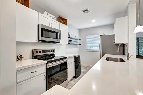 a kitchen with stainless steel appliances a stove microwave and a sink