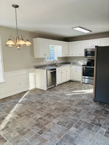 a kitchen with stainless steel appliances granite countertop a sink refrigerator and cabinets