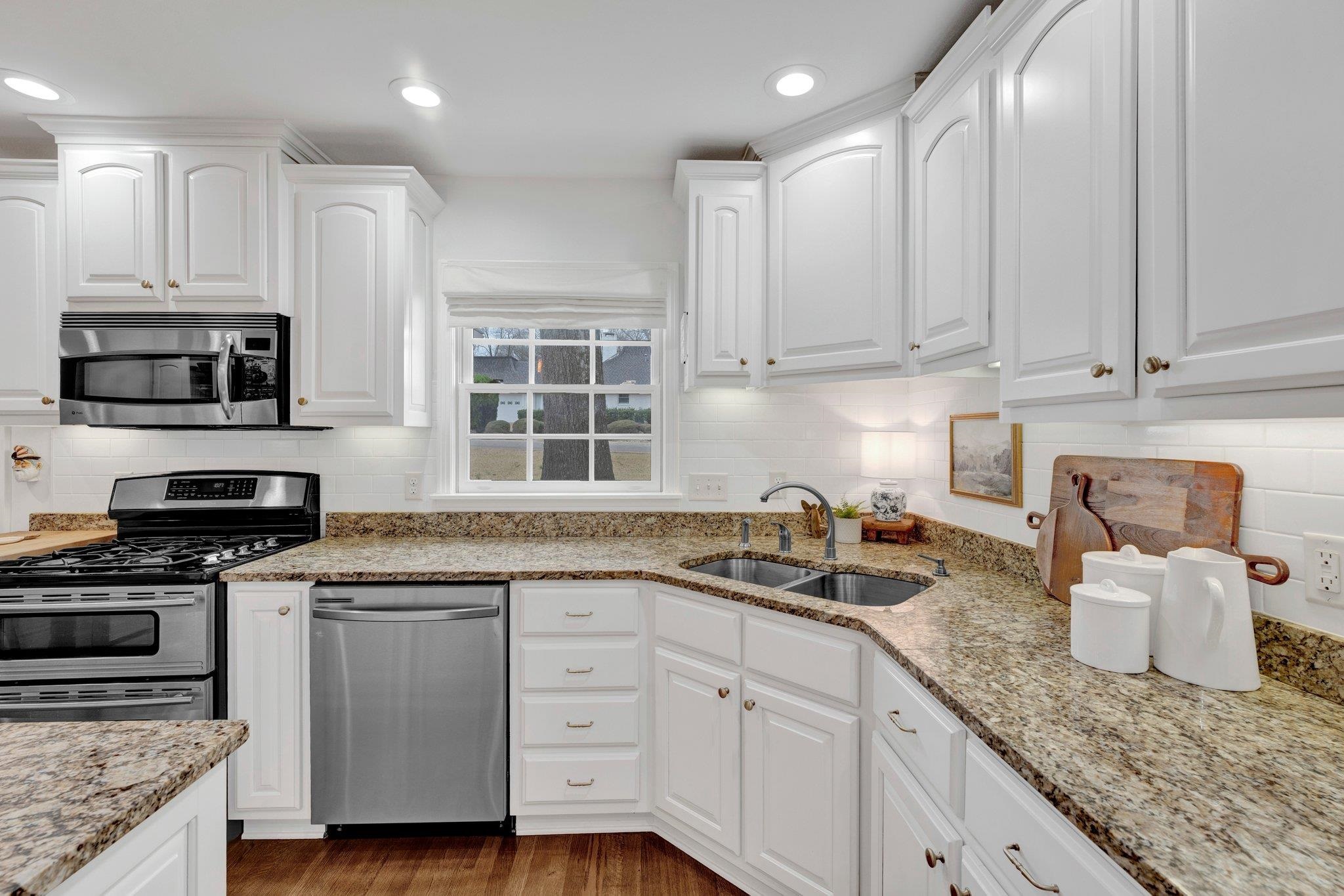 5481 Walnut Grove Road Memphis, TN 38120 - Photo 12 of 40 a kitchen with granite countertop white cabinets and stainless steel appliances
