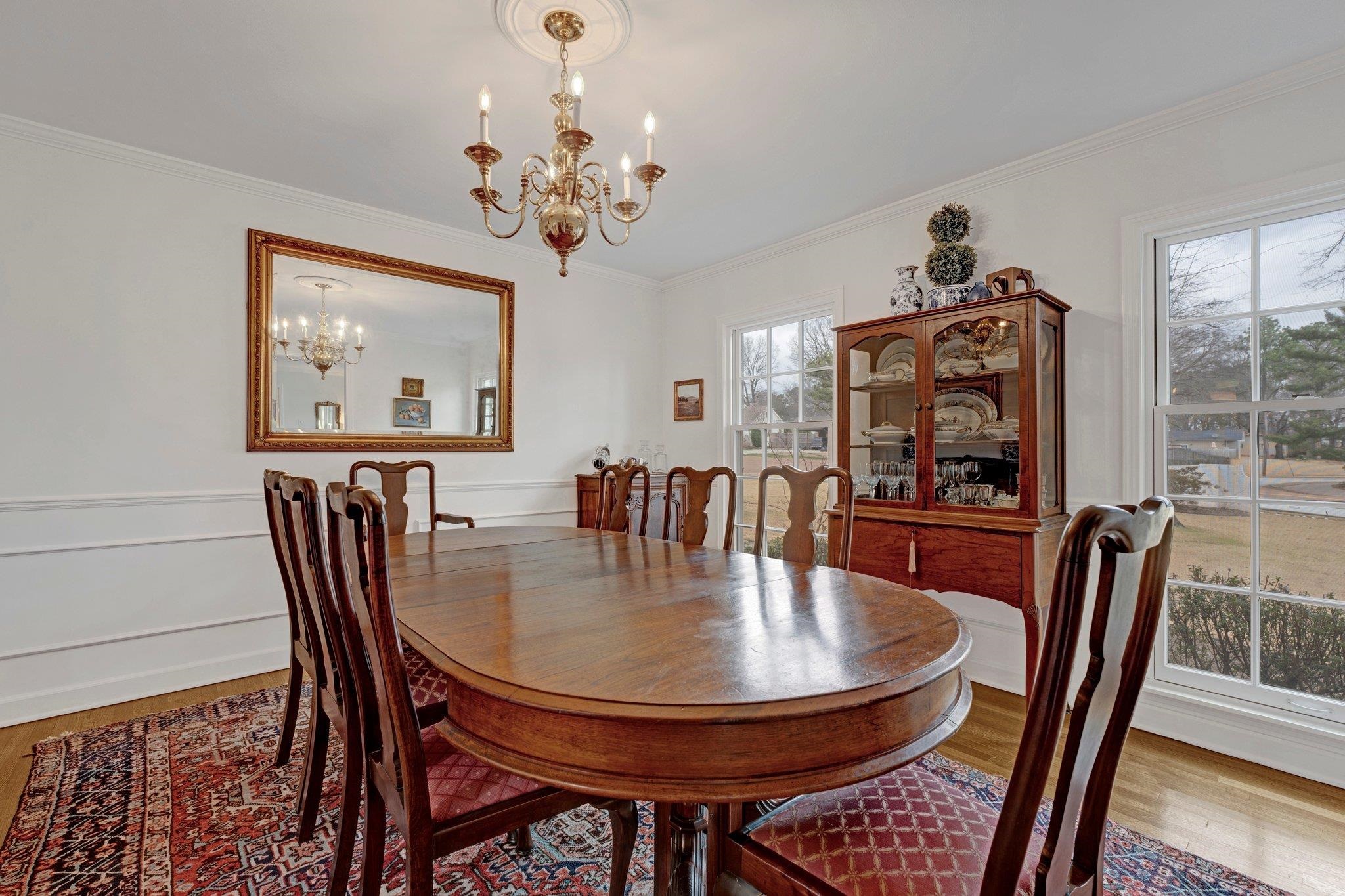 5481 Walnut Grove Road Memphis, TN 38120 - Photo 25 of 40 a dining room with furniture a rug and a chandelier