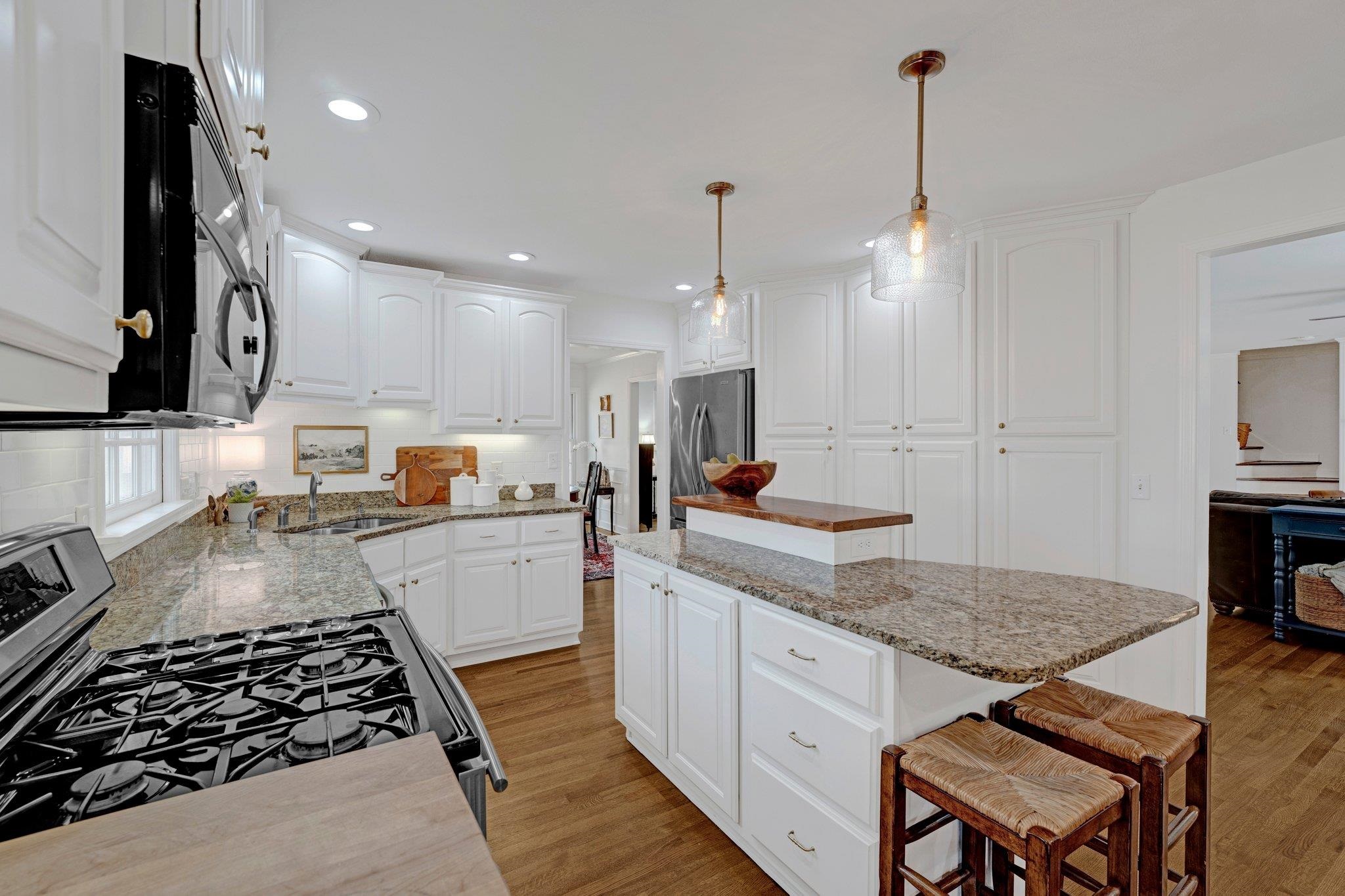 5481 Walnut Grove Road Memphis, TN 38120 - Photo 6 of 40 a kitchen with a stove a sink a refrigerator and chairs