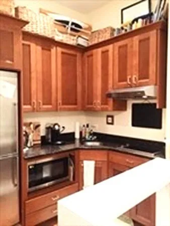 a kitchen with granite countertop a stove top oven microwave and cabinets