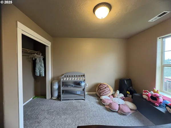 a bed sitting in a bedroom next to a window