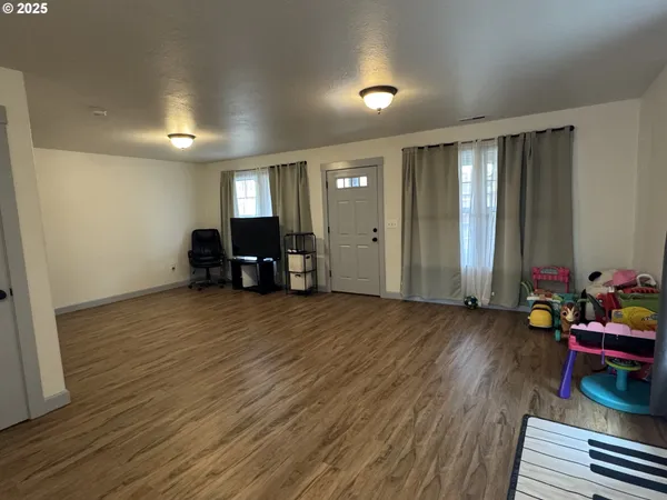 an empty room with wooden floor and furniture