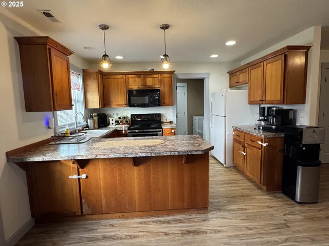 a kitchen with kitchen island granite countertop a sink stove and refrigerator