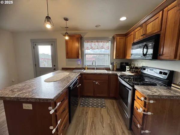 a kitchen with stainless steel appliances granite countertop a sink stove and cabinets