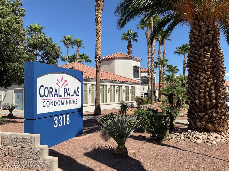 3318 North Decatur Boulevard, Unit 2152 Las Vegas, NV 89130 - Photo 33 of 58 Experience tropical living at Coral Palms Condominiums, featuring elegant stucco architecture and a vibrant landscape of palms.