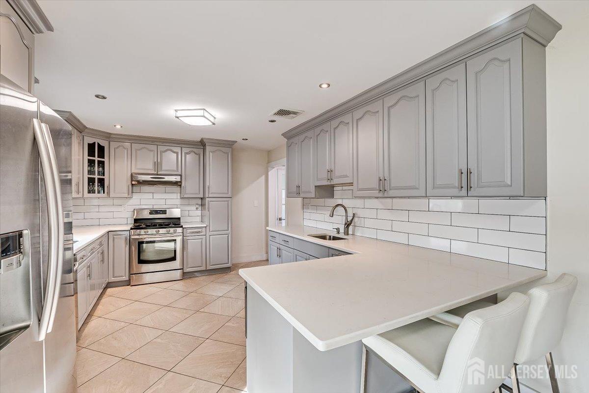 28 Clark Avenue Edison, NJ 08817 - Photo 20 of 47 a kitchen with kitchen island a stove a sink and a refrigerator