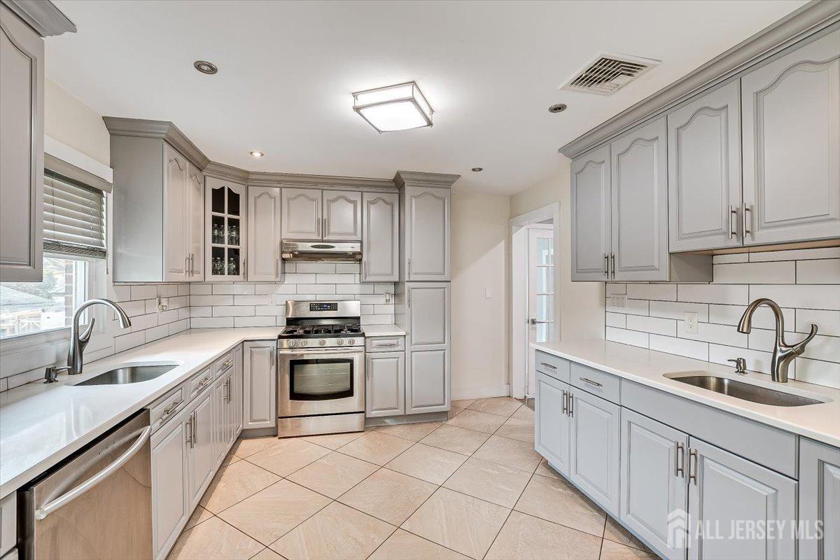 28 Clark Avenue Edison, NJ 08817 - Photo 21 of 47 a kitchen with white cabinets sink and stainless steel appliances