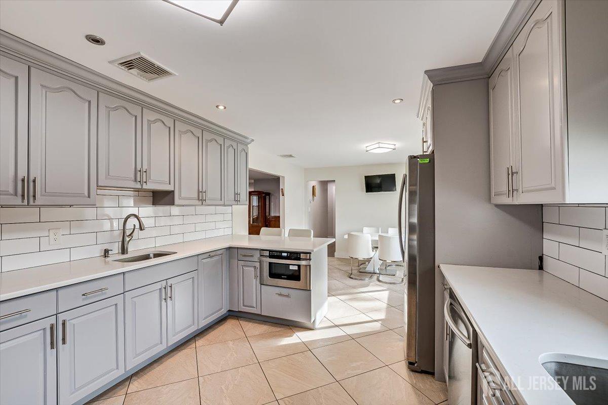 28 Clark Avenue Edison, NJ 08817 - Photo 24 of 47 a kitchen with a sink white cabinets and stainless steel appliances