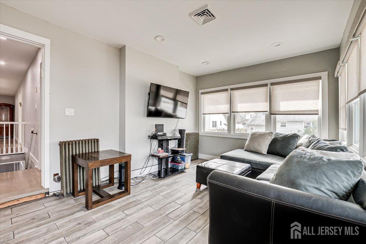 28 Clark Avenue Edison, NJ 08817 - Photo 26 of 47 a living room with furniture and a flat screen tv with wooden floor