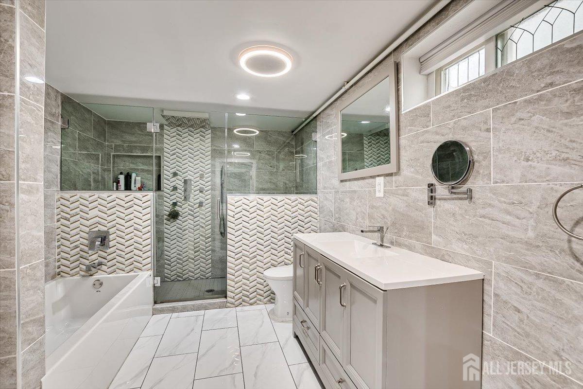 28 Clark Avenue Edison, NJ 08817 - Photo 41 of 47 a bathroom with a sink a mirror and a bathtub