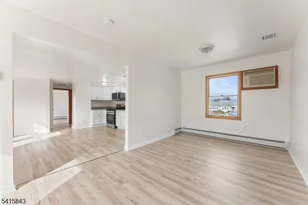 a view of a kitchen with wooden floor and a window