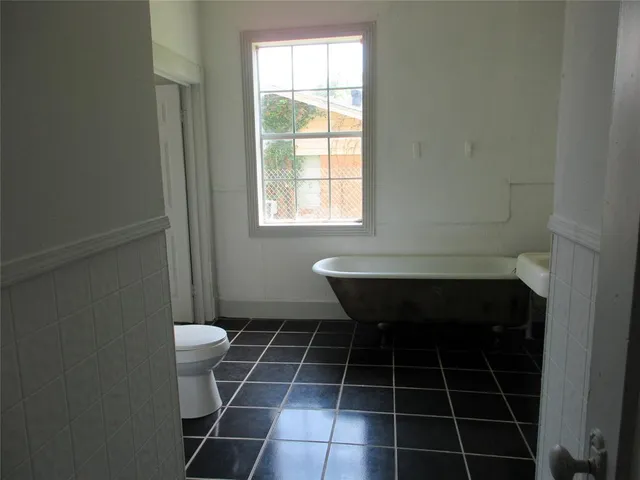 a bathroom with a toilet a sink and a window