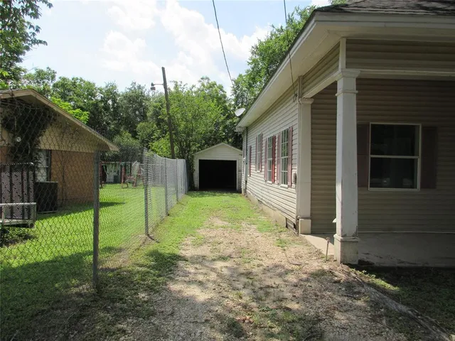 a view of a house with backyard and a tree