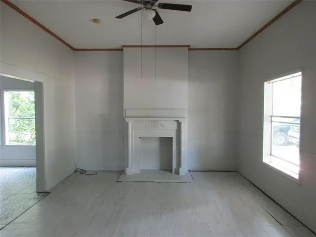 an empty room with a fireplace and windows