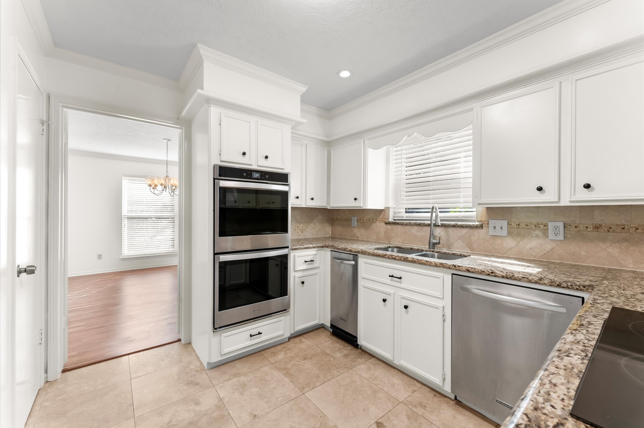 7311 17th Green Drive Humble, TX 77346 - Photo 8 of 32 a kitchen with granite countertop white cabinets a sink and dishwasher next to a window
