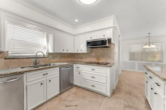 a kitchen with granite countertop a sink and cabinets