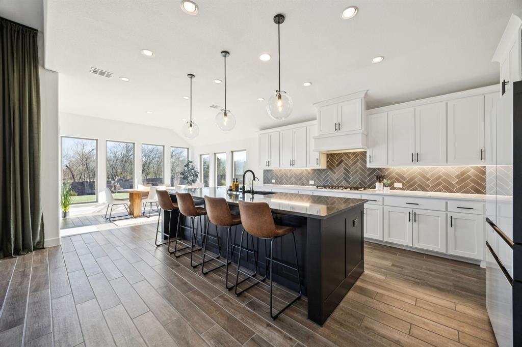 1551 Ripasso Way McLendon-Chisholm, TX 75032 - Photo 11 of 39 a large kitchen with kitchen island granite countertop a large window and white cabinets
