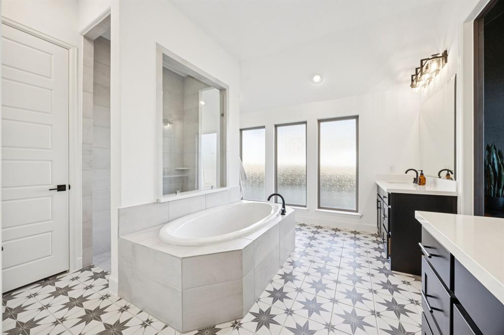 1551 Ripasso Way McLendon-Chisholm, TX 75032 - Photo 17 of 39 a spacious bathroom with a tub a double vanity sink a mirror and shower