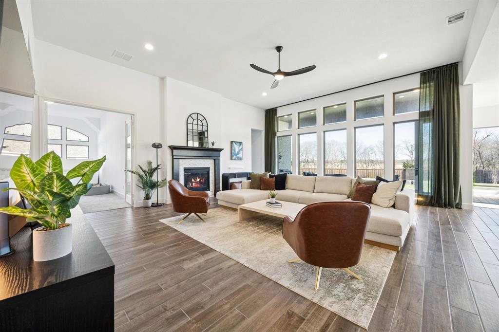 1551 Ripasso Way McLendon-Chisholm, TX 75032 - Photo 8 of 39 a living room with fireplace furniture and a wooden floor