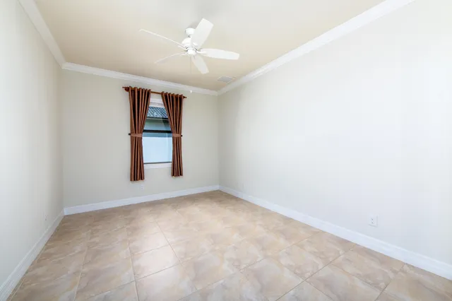 an empty room with windows and ceiling fan