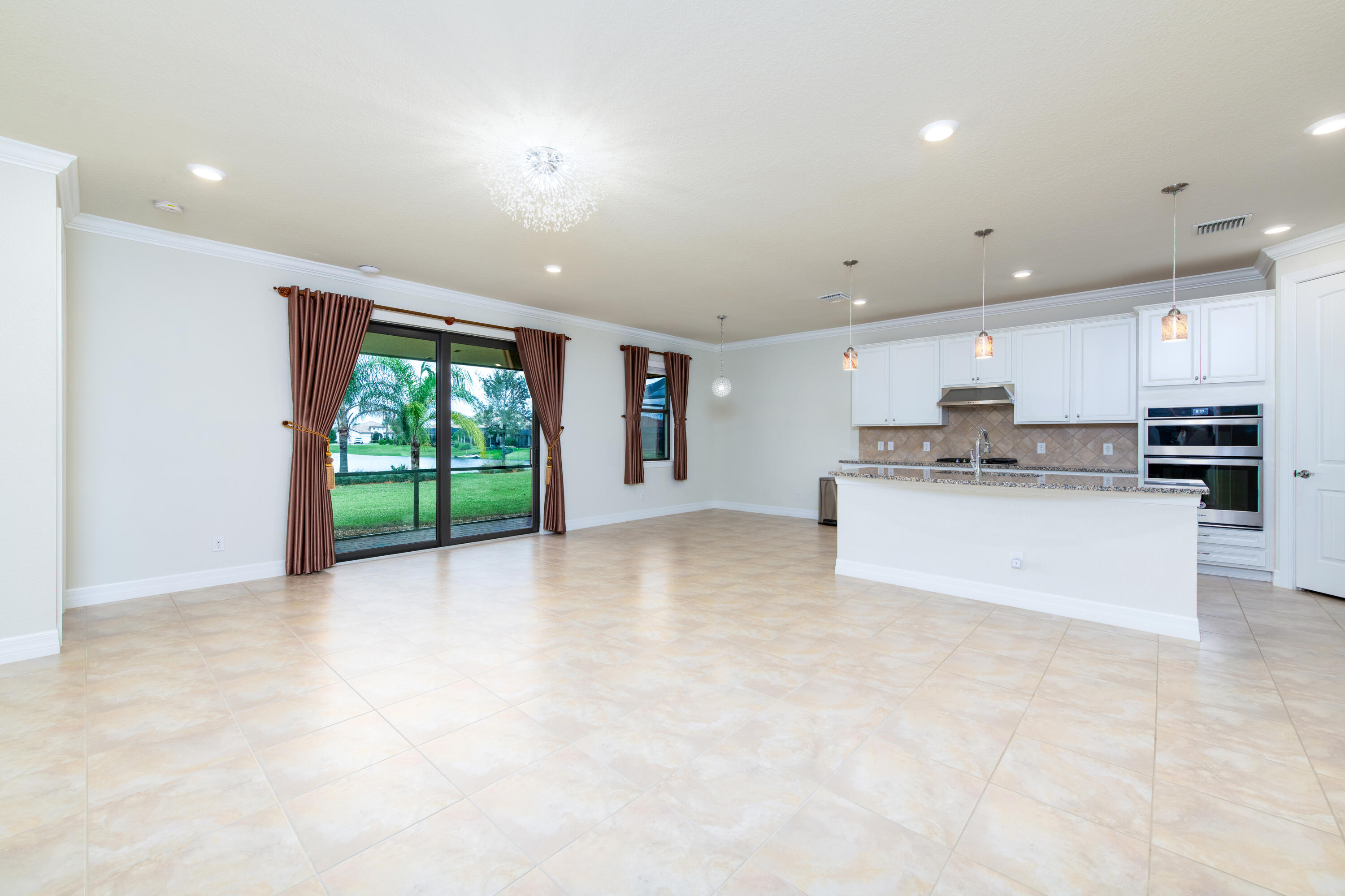 739 Southeast Villandry Way Port St. Lucie, FL 34984 - Photo 27 of 51 a view of kitchen with stainless steel appliances granite countertop a stove top oven a sink dishwasher and white cabinets with wooden floor