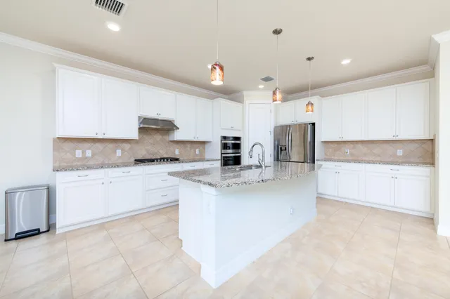 a kitchen with stainless steel appliances granite countertop a sink and a refrigerator