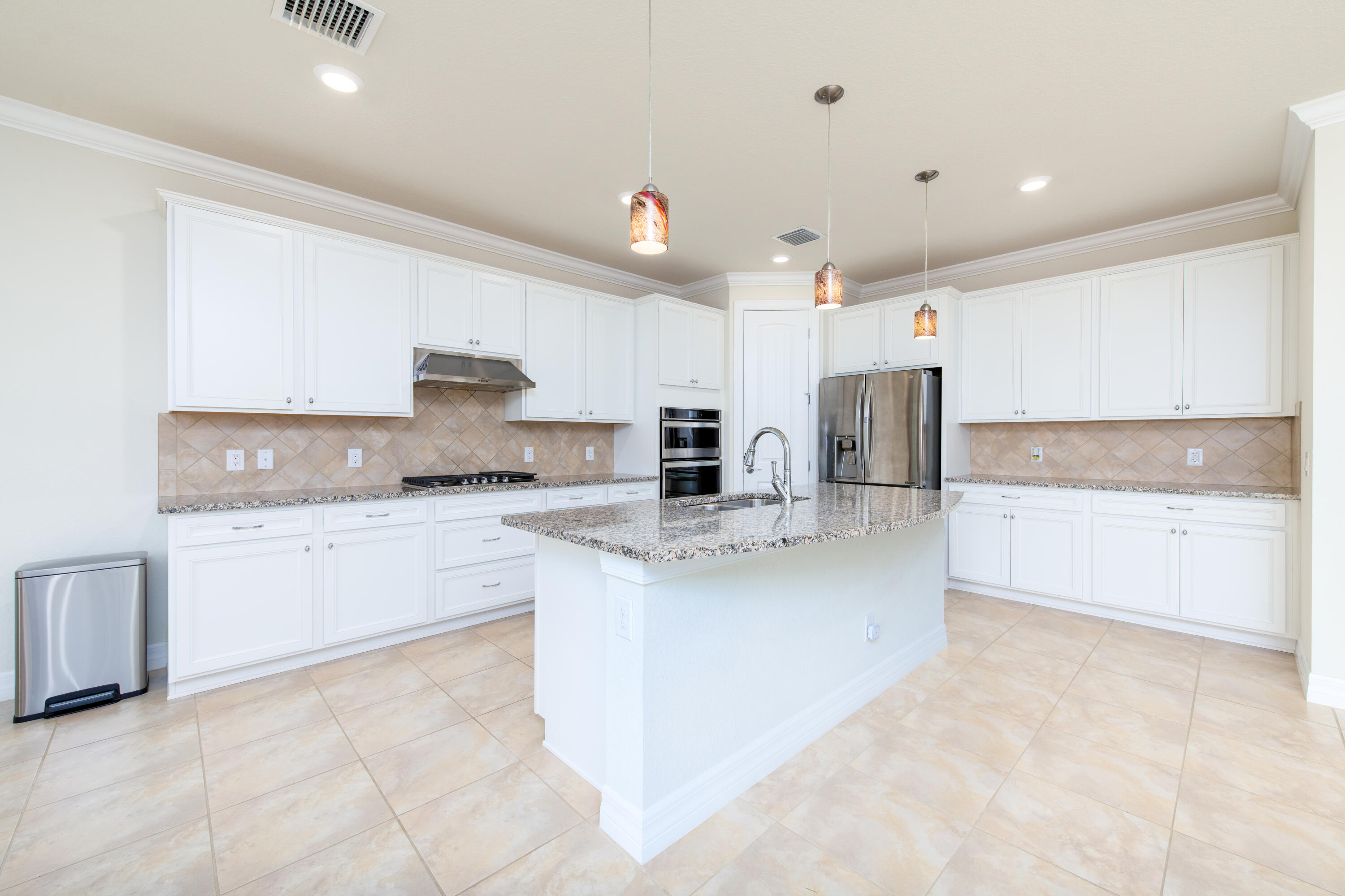 739 Southeast Villandry Way Port St. Lucie, FL 34984 - Photo 29 of 51 a large kitchen with stainless steel appliances kitchen island granite countertop a stove a sink a refrigerator and white cabinets