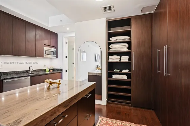a kitchen with stainless steel appliances granite countertop a refrigerator and a stove top oven