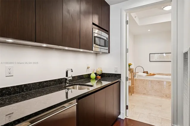 a kitchen with granite countertop stainless steel appliances a sink stove and cabinets