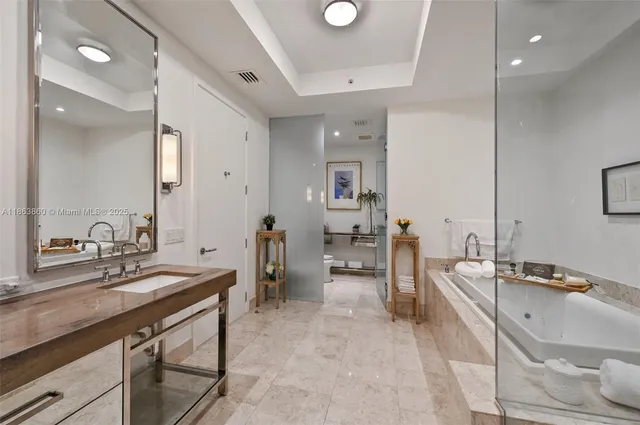 a bathroom with a double vanity sink a mirror and a bathtub