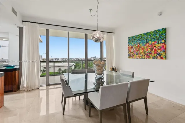 a dining room with furniture and a floor to ceiling window