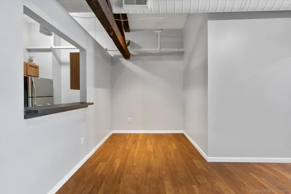 a view of a room with wooden floor and door