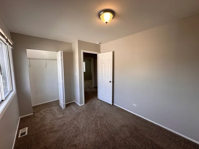 an empty room with closet and windows