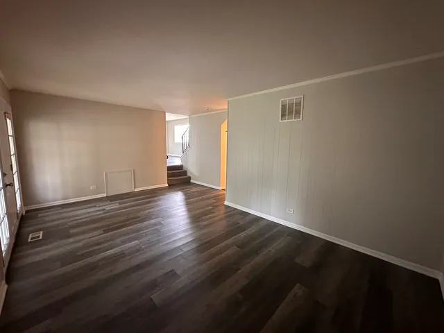 a view of an empty room with wooden floor