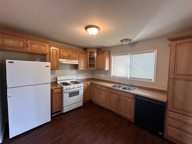 a kitchen with appliances a sink and a refrigerator