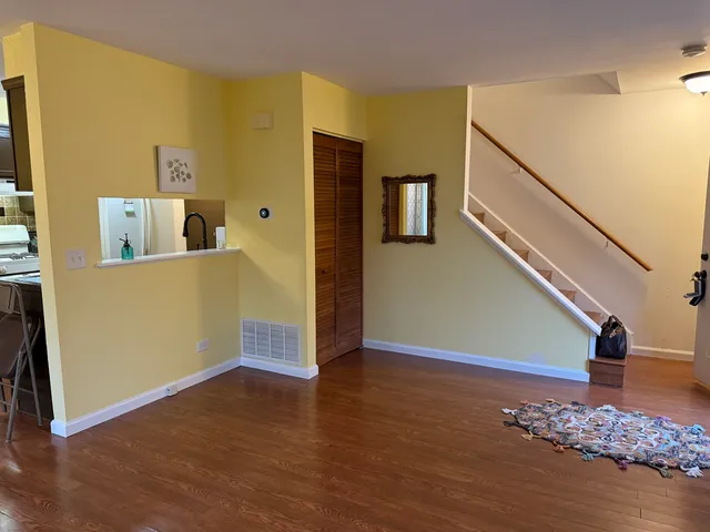 a view of a livingroom with wooden floor and stairs