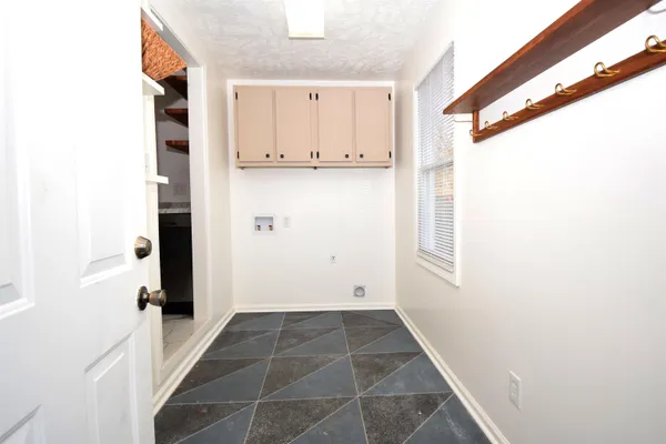 a view of a hallway with wooden cabinets and windows