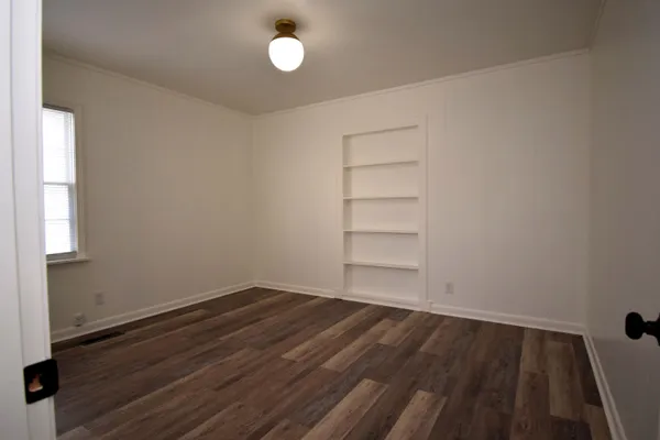 a view of a room with wooden floor and window