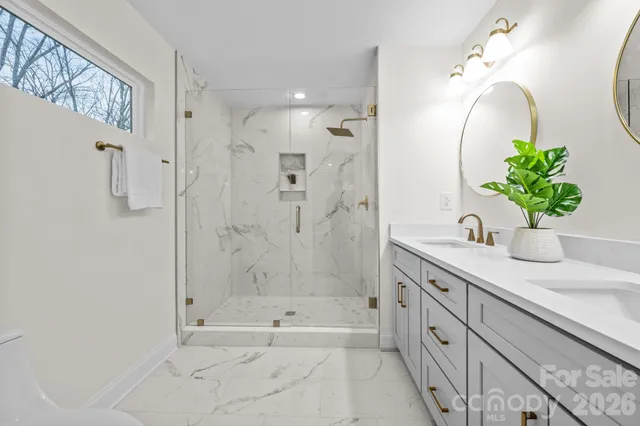 a bathroom with a granite countertop sink a toilet and shower