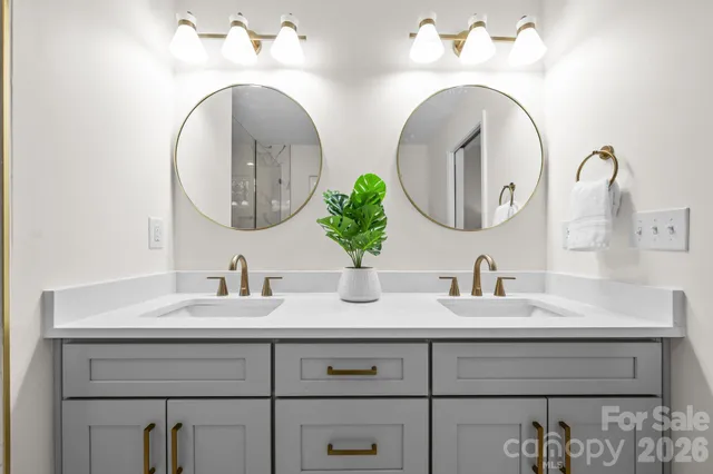 a bathroom with double vanity sinks and two mirror