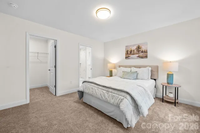a spacious bedroom with a bed and a painting on the wall