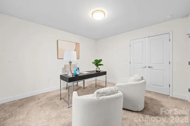 a living room with furniture a window and a potted plant