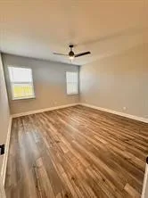 an empty room with a window and a ceiling fan