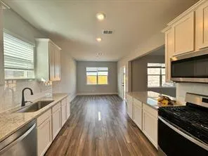 a kitchen with granite countertop a stove and a sink