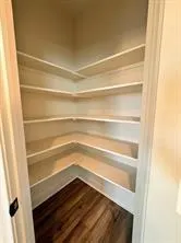a view of walk in closet with empty racks